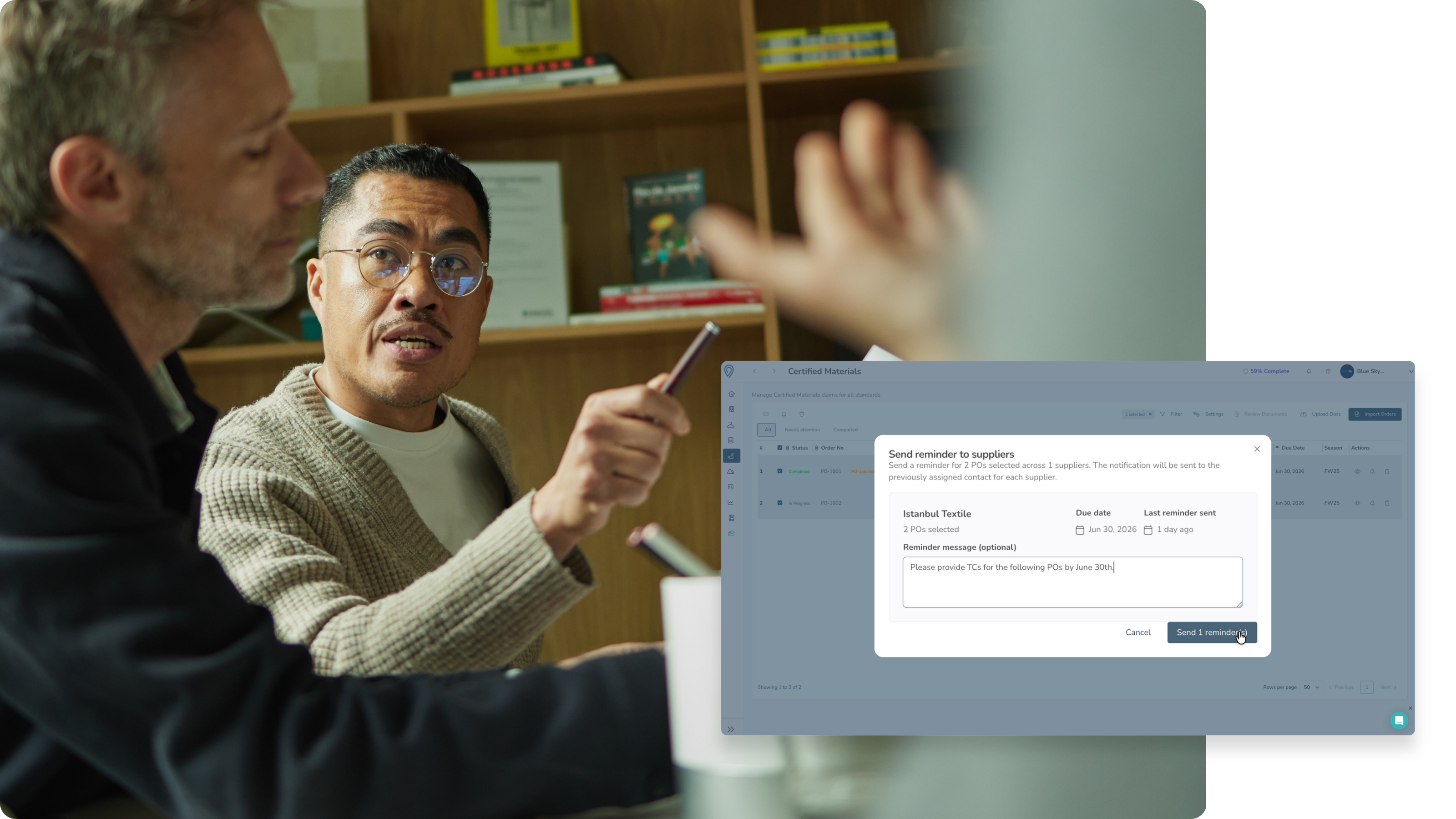 Two men in a discussion with a computer screen overlay showing a form.