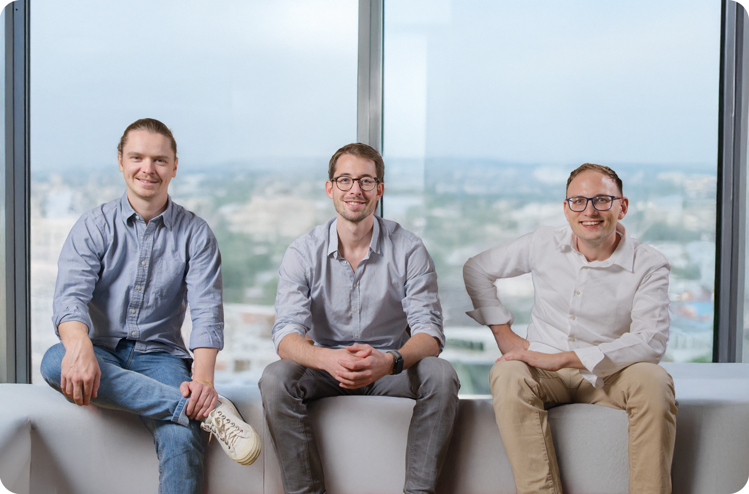Retraced co-founders Lukas Pünder, Philip Mayer, and Peter Merkert seated and smiling, representing leadership in sustainable fashion innovation