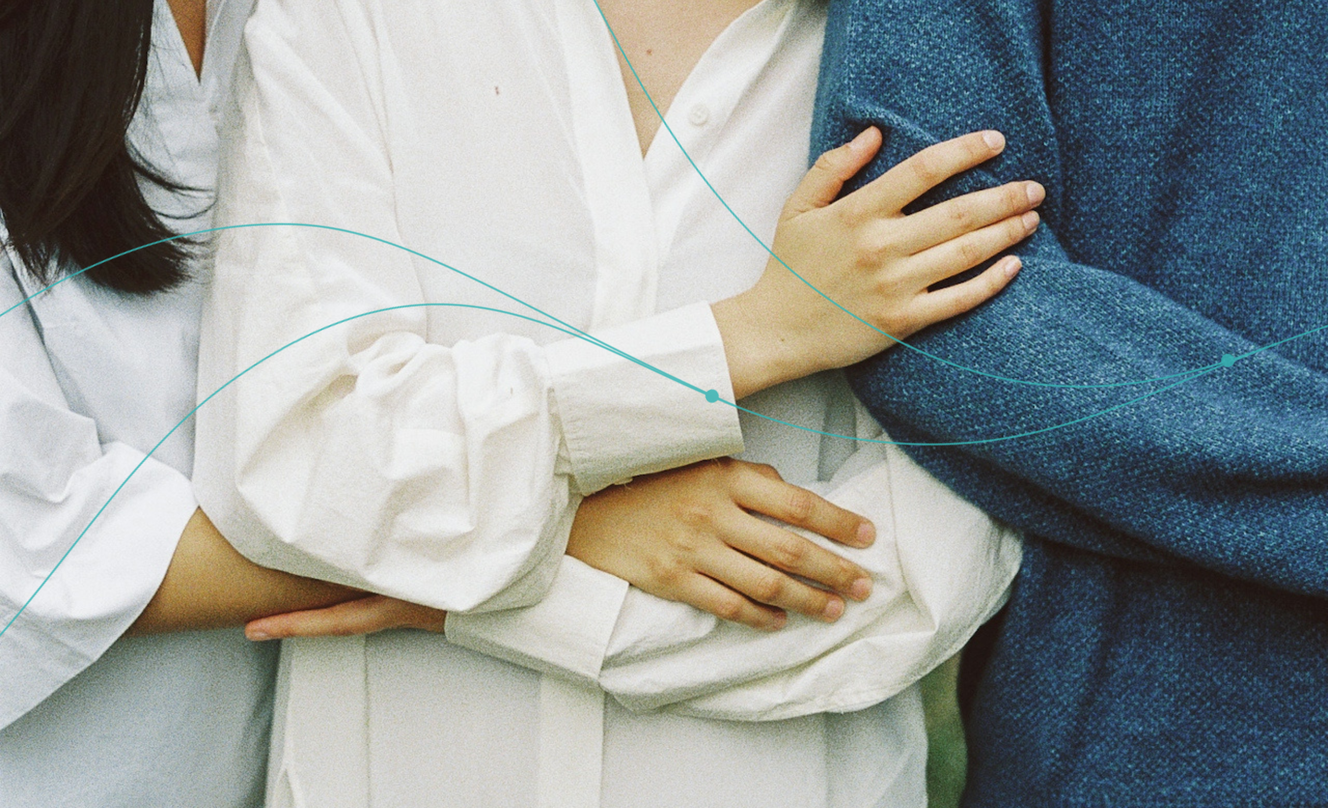 Two people in white robes embracing, with one person wearing a blue robe.